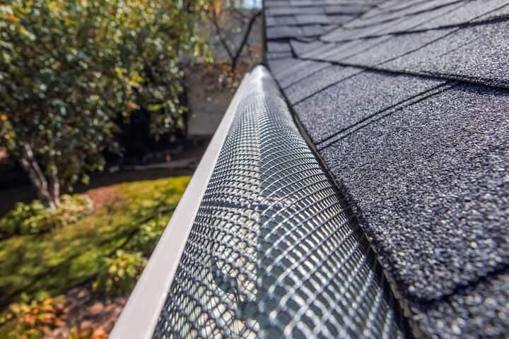 A contractor demonstrating the effectiveness of a gutter guard to a potential client in San Jose